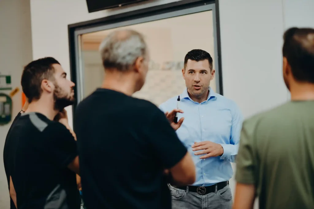 Alexander Baliet erklärt etwas vor Leuten in der Produktion